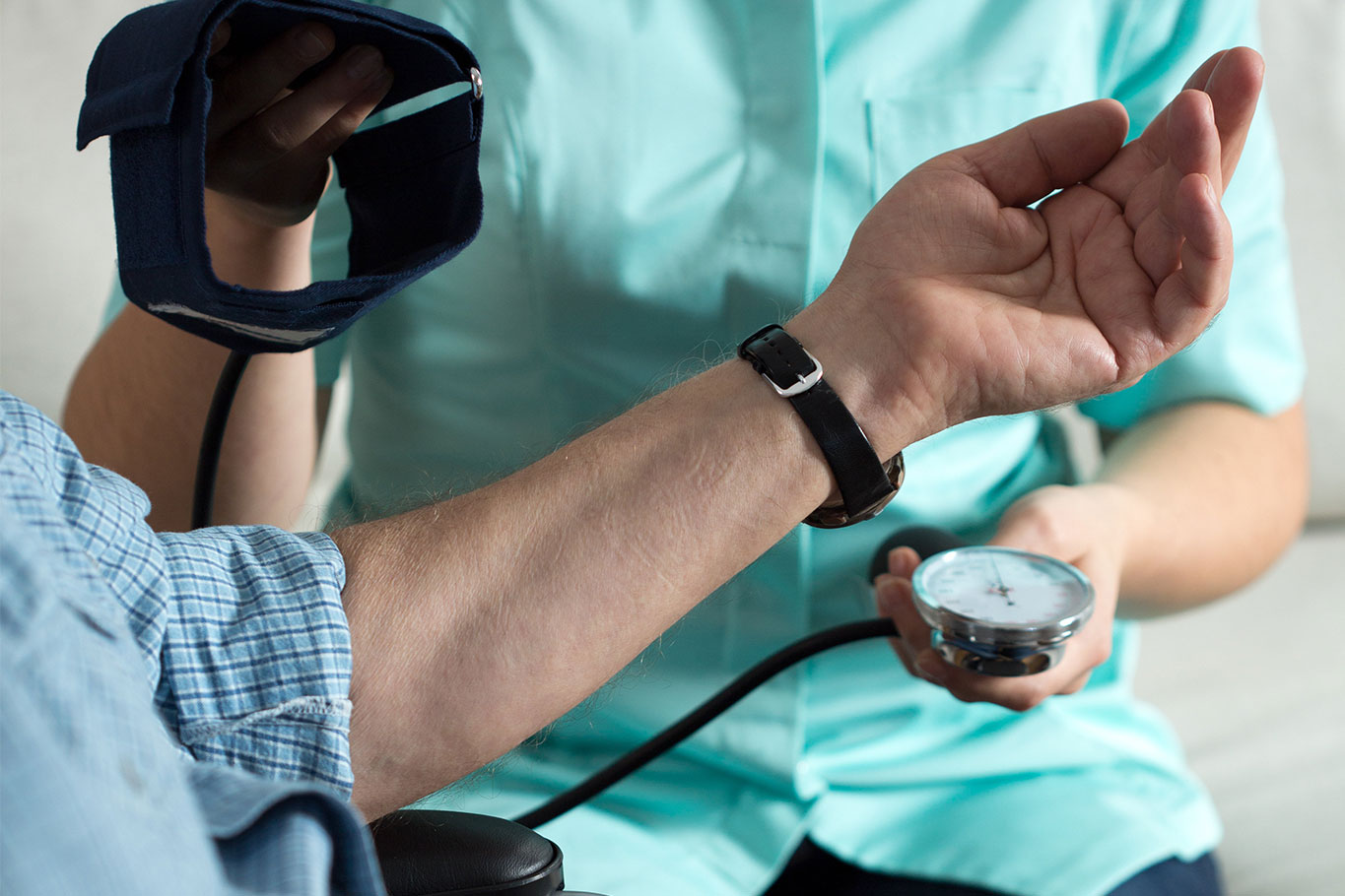 Home care nurse taking blood pressure after orthopedic surgery 