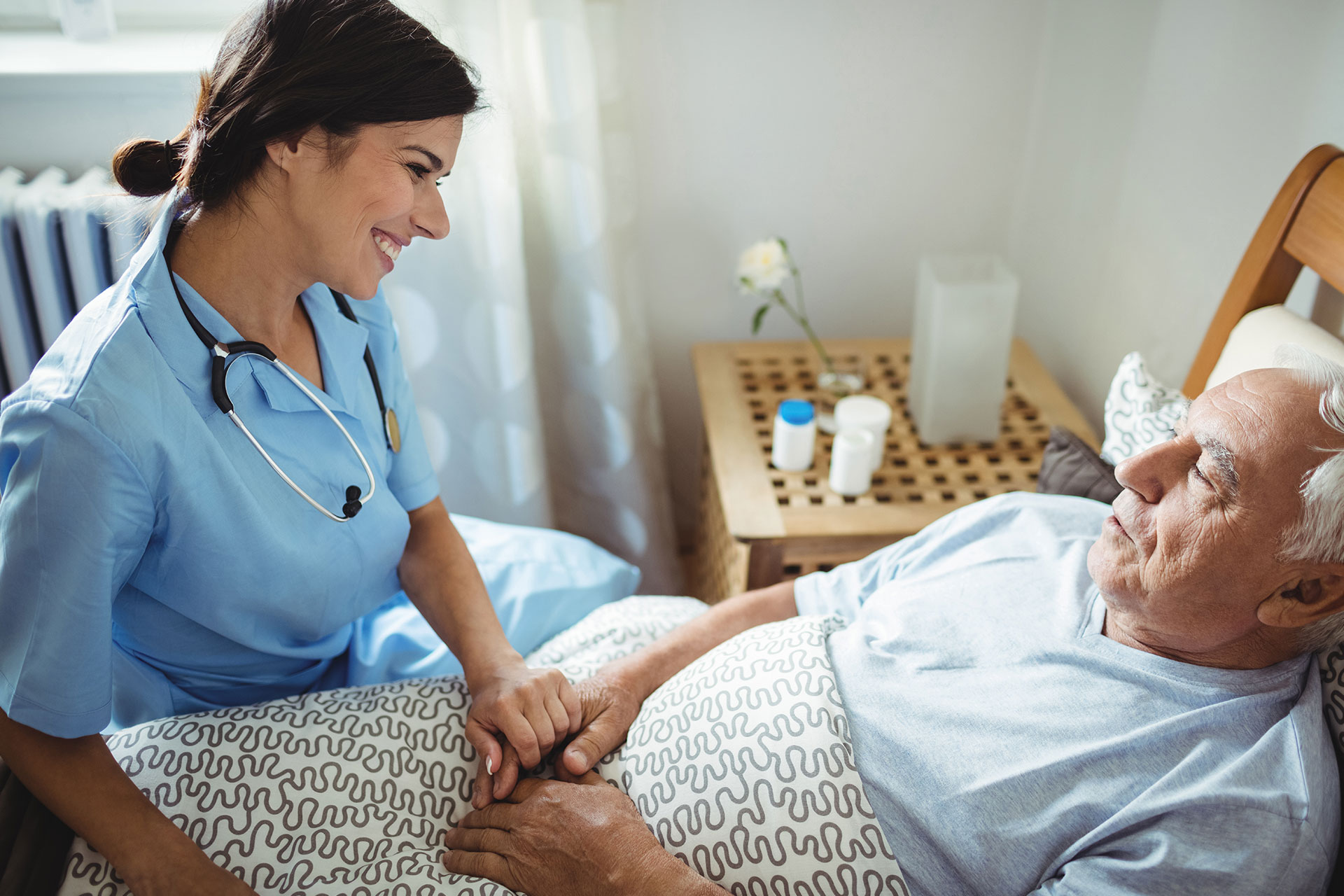 nurse helping bed bound patient