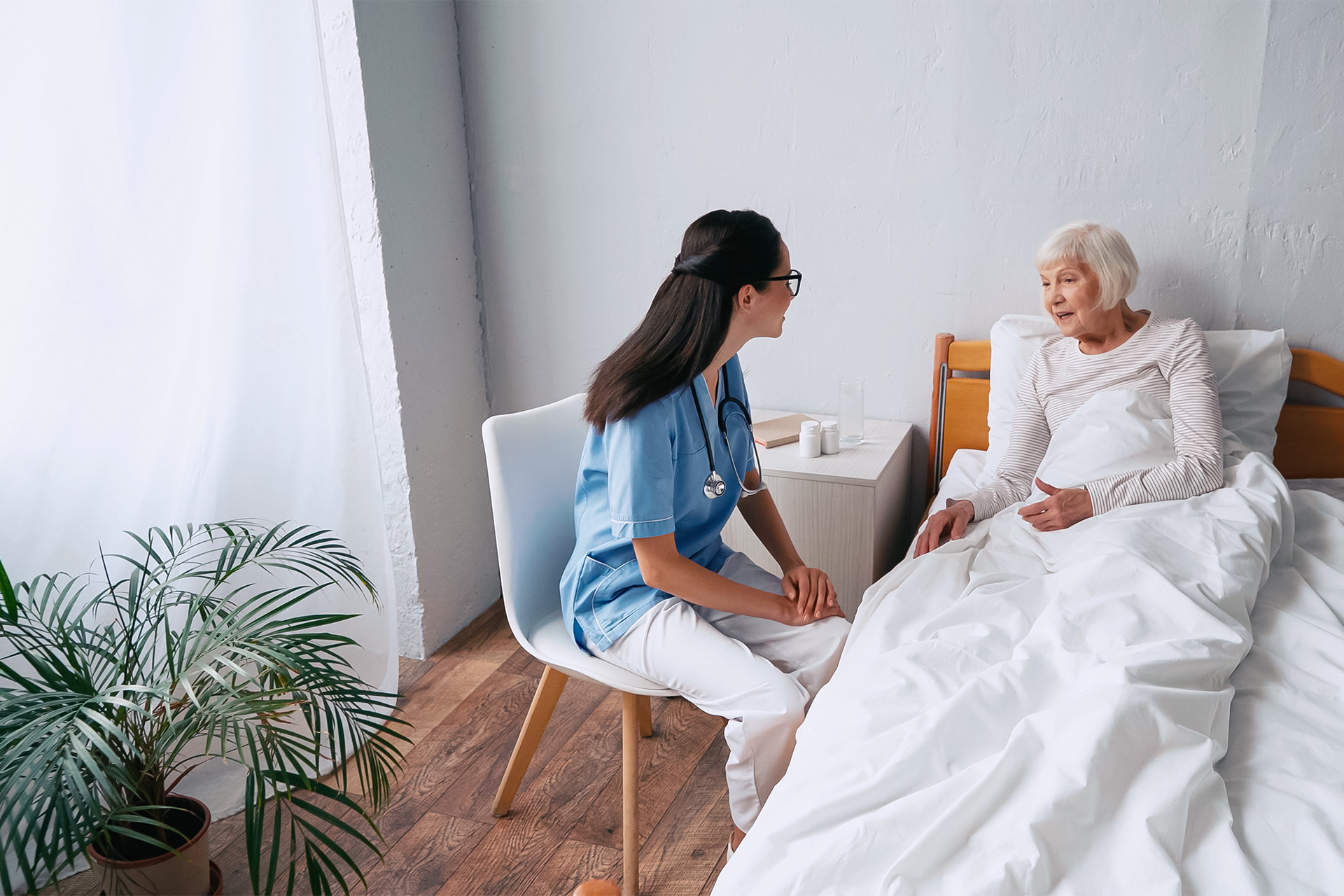 nurse talking with patient in bed