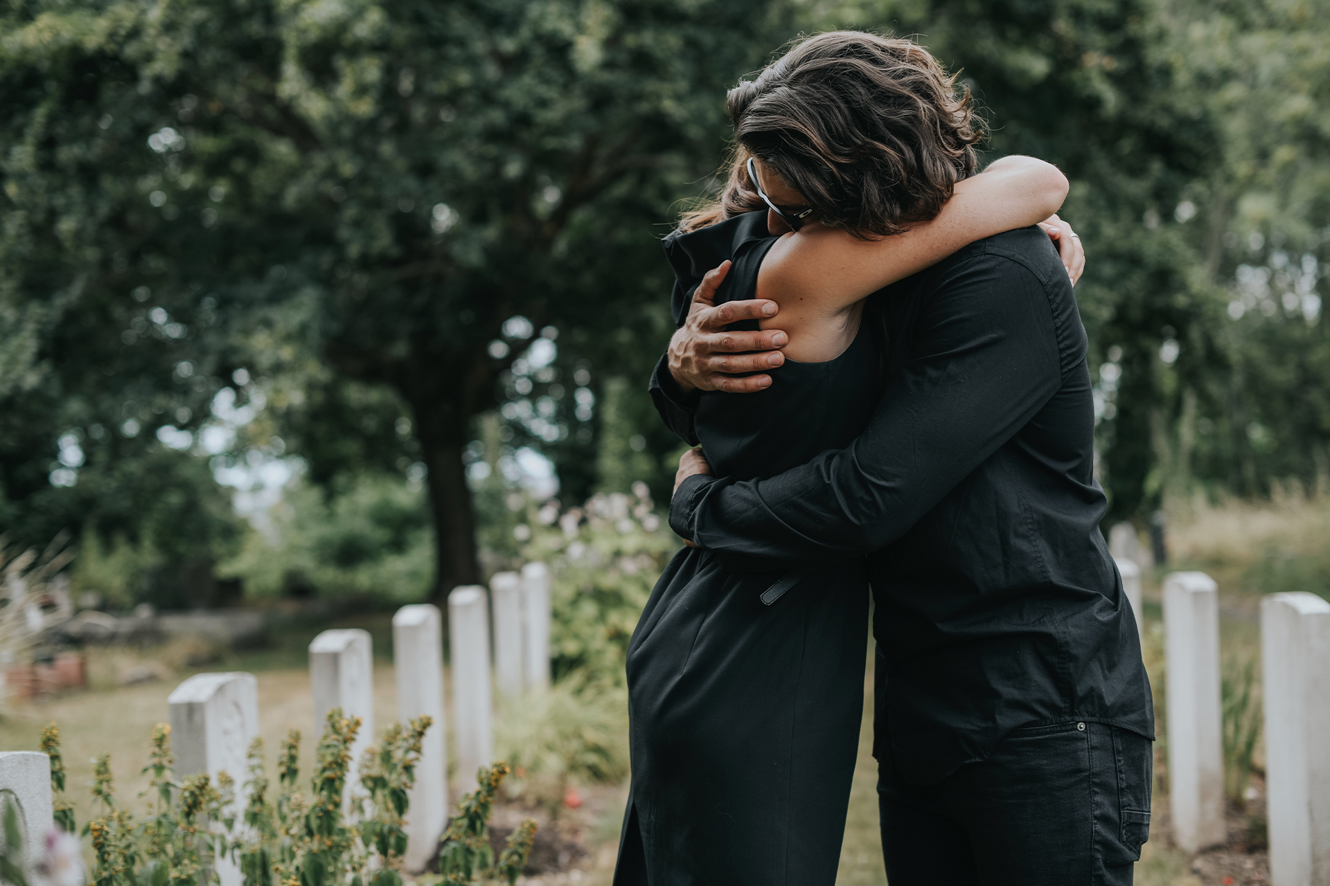 Woman hugging her friend at a funeral