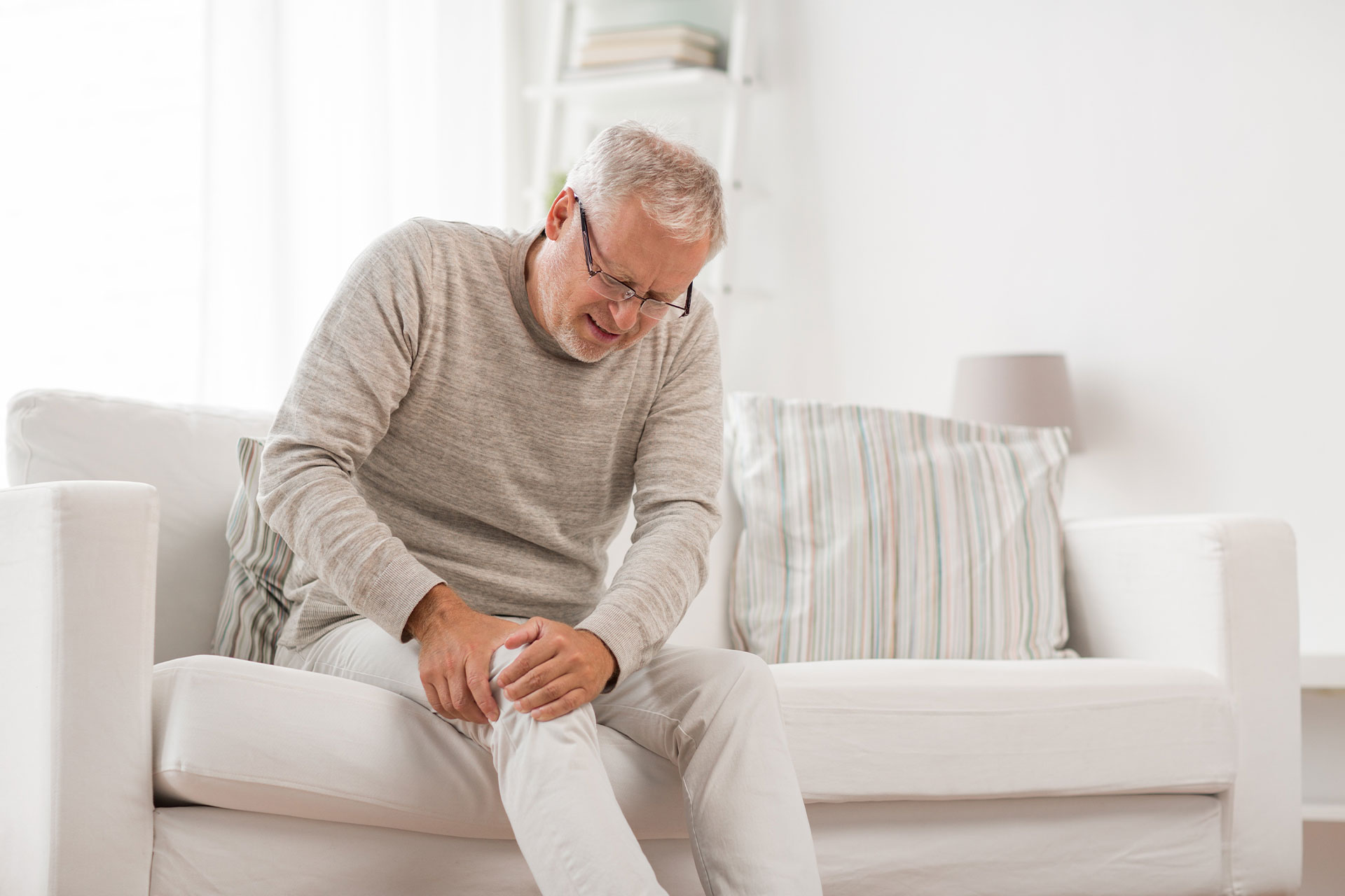 man on couch with knee pain