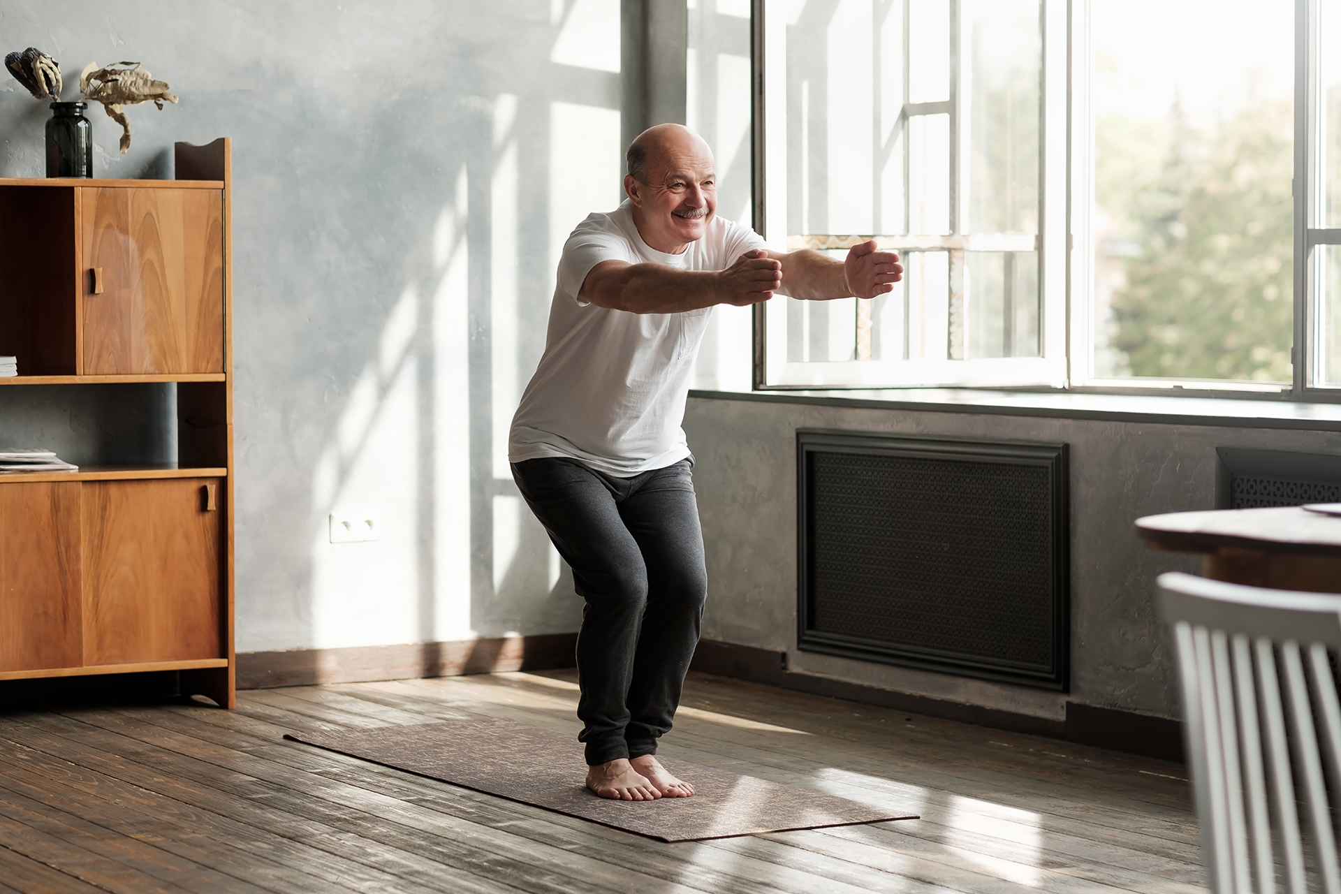 Older man in at home yoga session