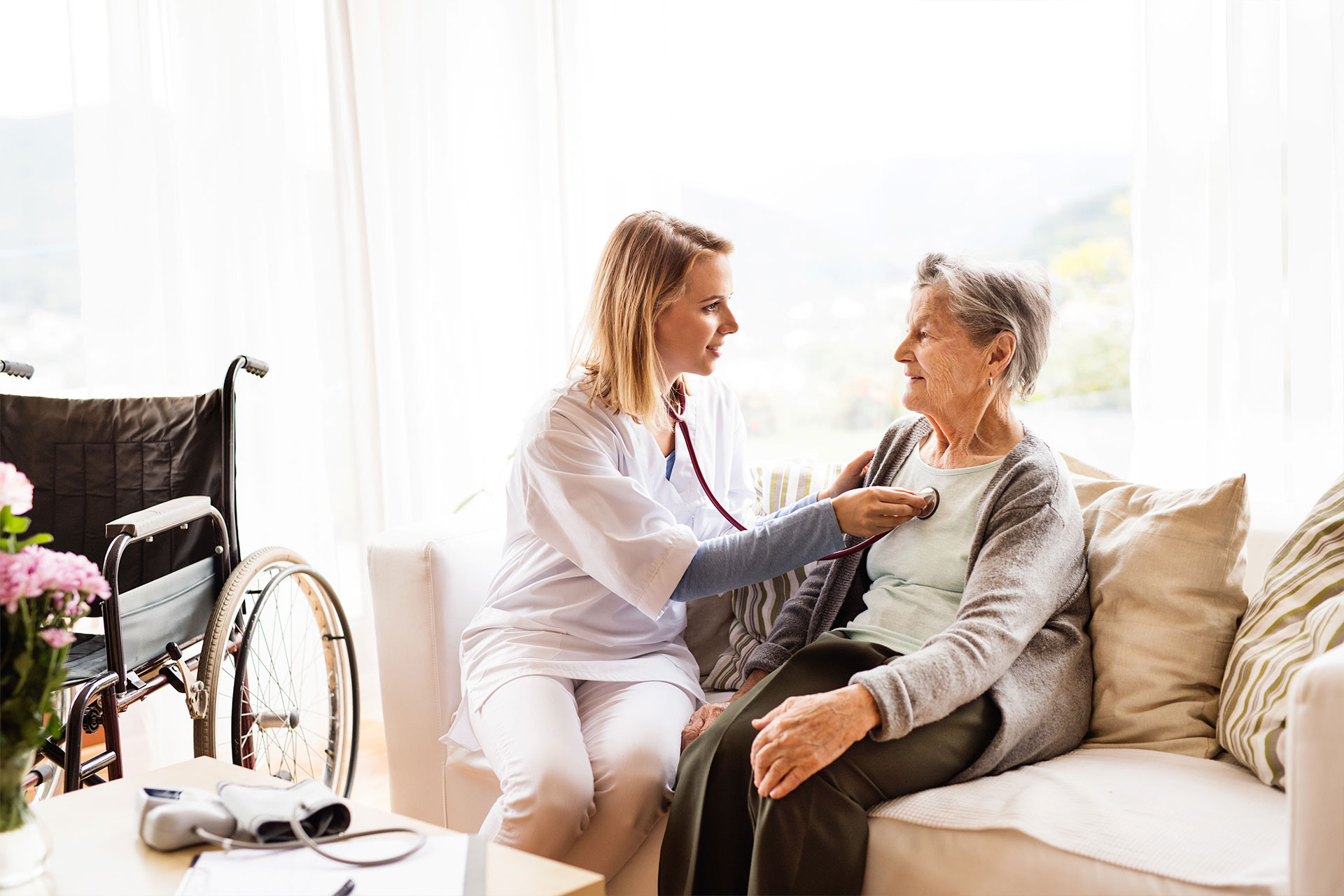 nurse checking patients heart at home