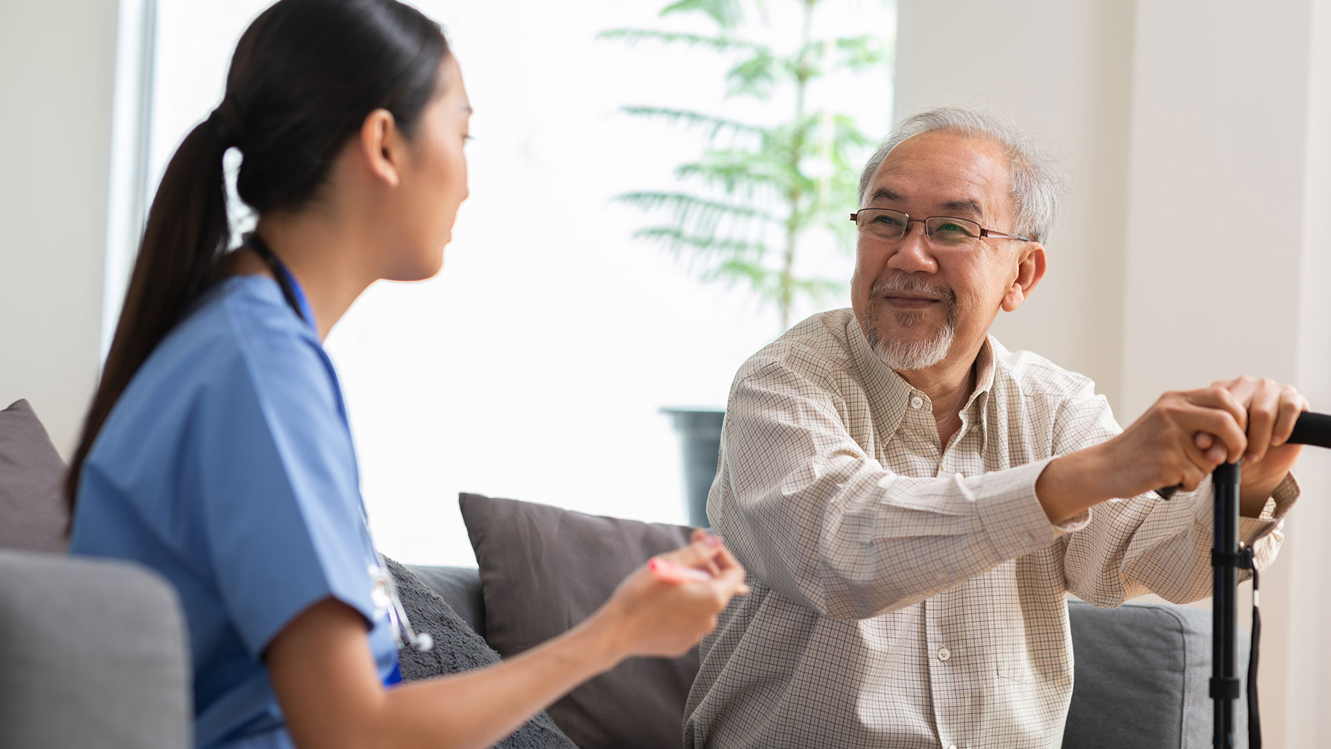 Asian nurse caring for older patient