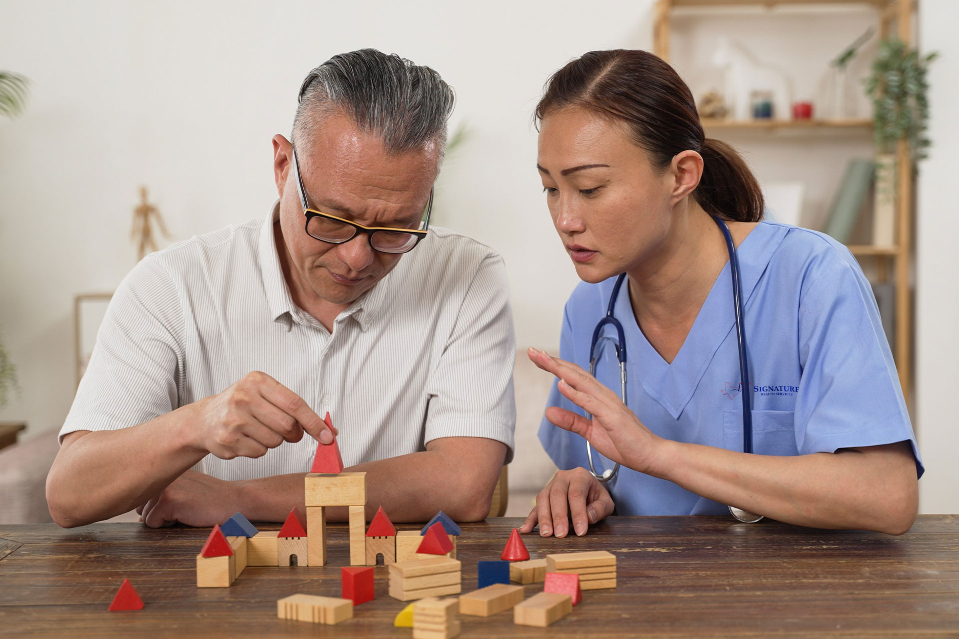 Nurse helping patient use blocks