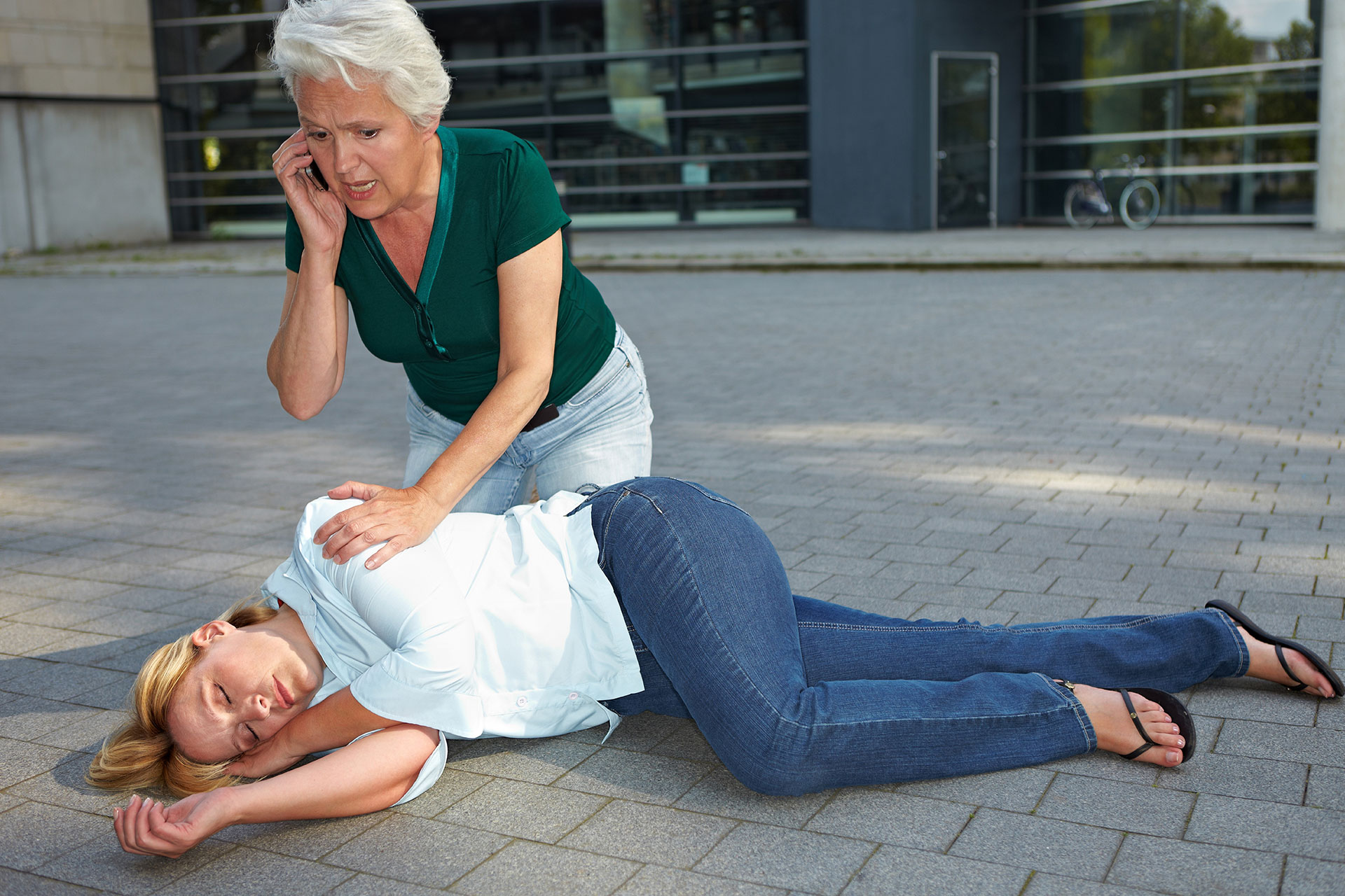 Woman having a seizure along a woman asking for help