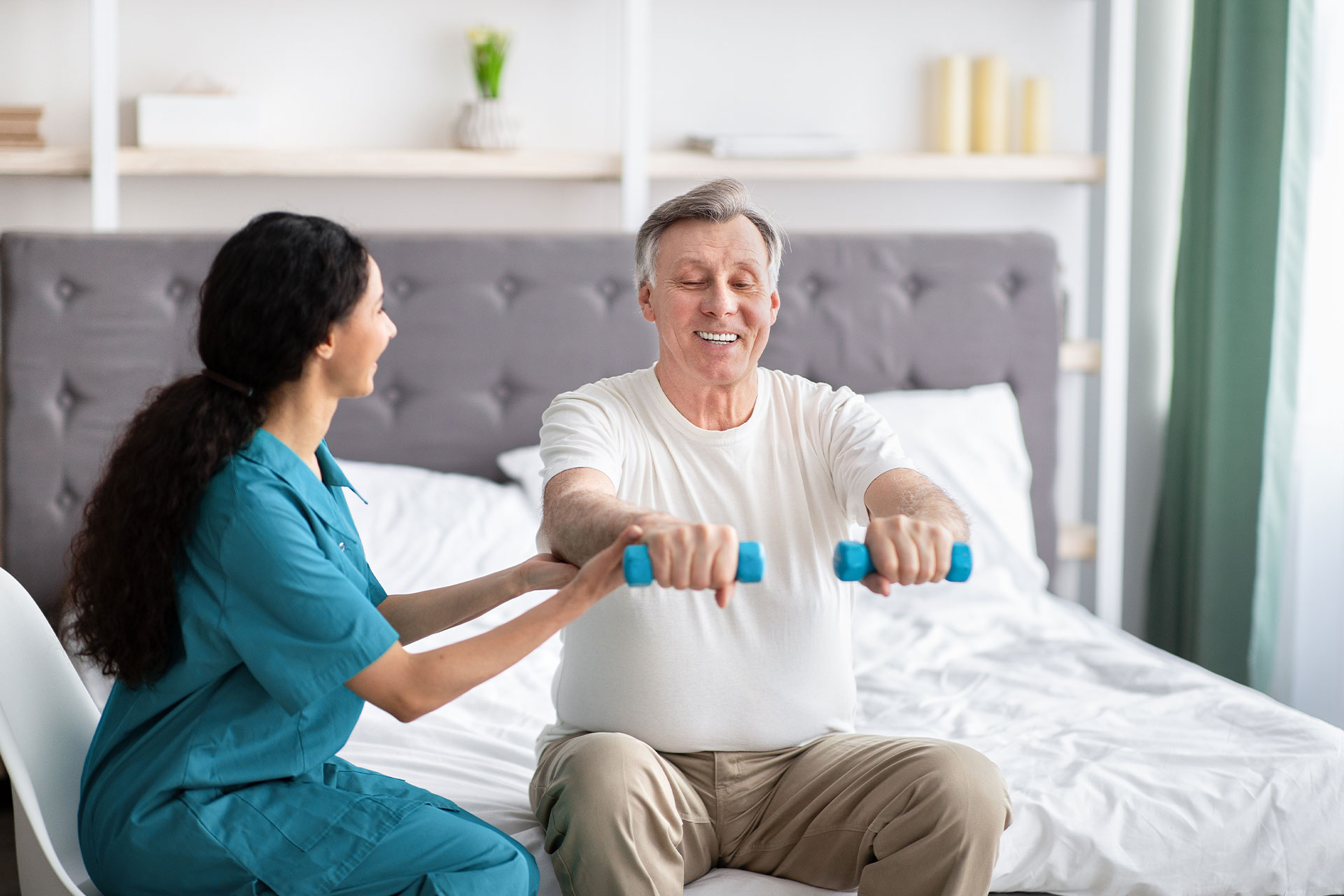 home nurse helping patients strengthen muscles in his arms