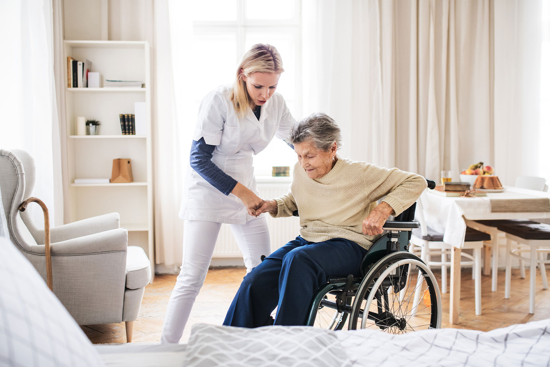 certified nurses aid (cna) helping patient out of wheelchair